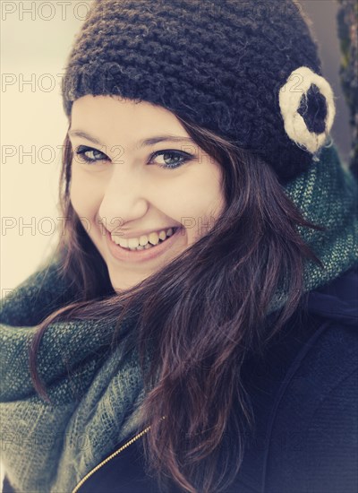 Smiling young woman wearing hat and scarf in winter