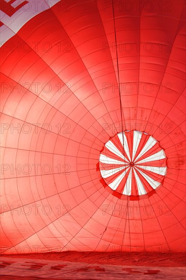 A red hot air balloon being inflated