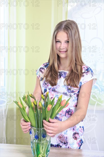 Portrait of a teenage girl at home with flowers