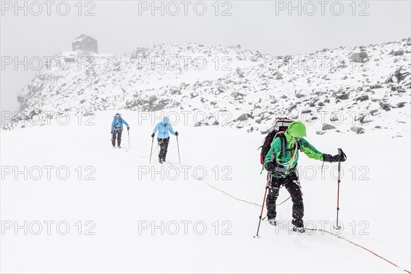 Rope team in a storm during the ascent of Mt Schwarzenstein via the glacier