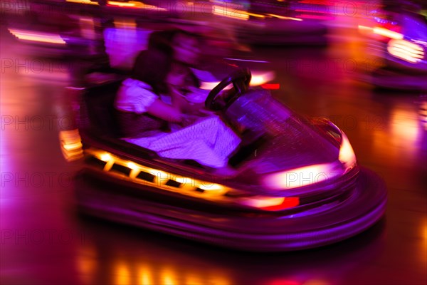 Couple driving bumper car at night