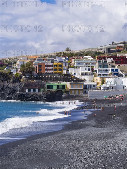 Tourists on the black beach of Puerto Naos