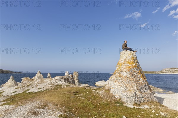 Hiker sitting on one of the legendary dolomite rocks on Porsangerfjorden fjord