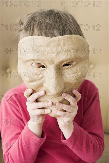 Girl hiding face behind mask
