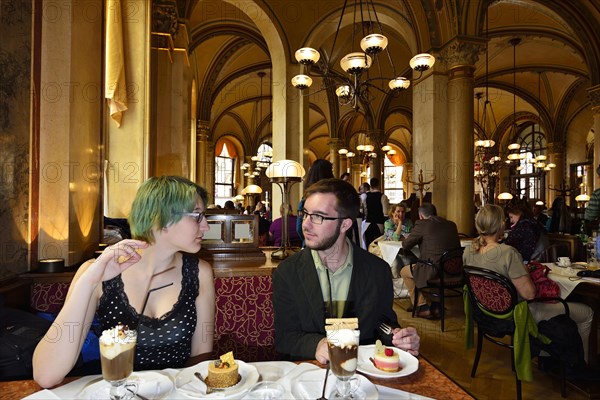 Young couple sitting at a table in the traditional Cafe Central