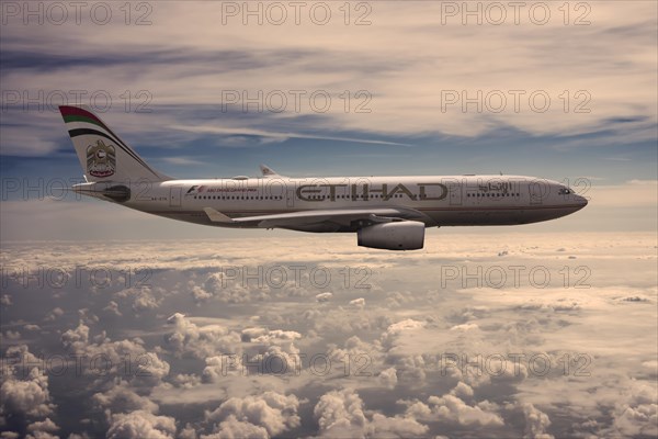 A6-EYK Etihad Airways Airbus A330-243 in flight above the clouds in the evening light