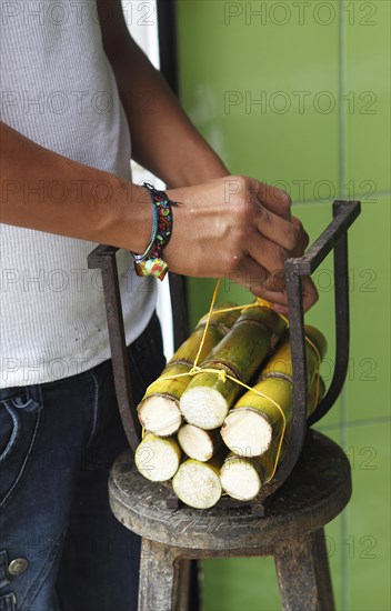 Men's hands tying cane rods for sale