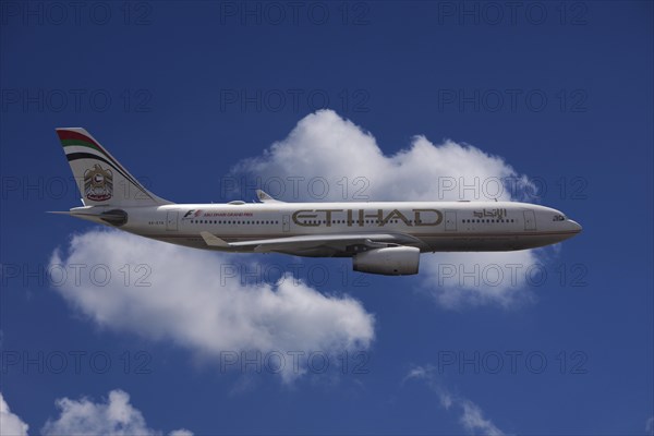 A6-EYK Etihad Airways Airbus A330-243 in flight against a cloudy sky