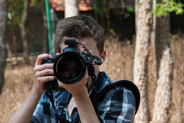 Teenager taking a photo with a professional camera