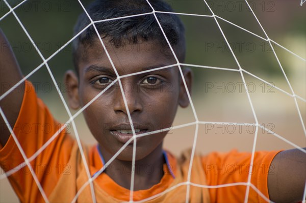 Boy looking through goal net