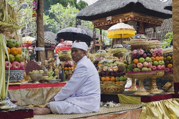 A Hindu priest amidst sacrificial offerings at a temple ceremony