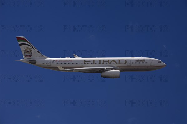 A6-EYK Etihad Airways Airbus A330-243 in flight against a blue sky