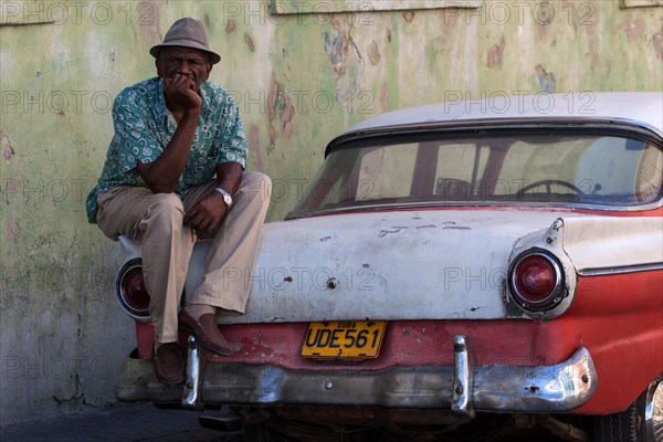 Cuban taxi driver with his vintage taxi