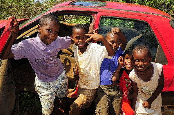 Happy children playing at a car wreck
