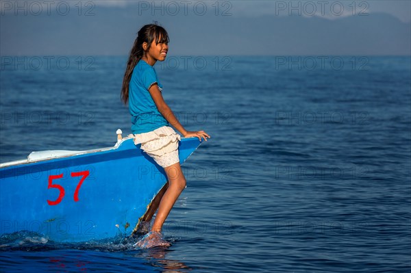 Girl sitting on small fishing boat