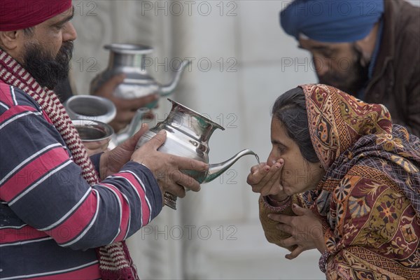 Pilgrims drinking holy water