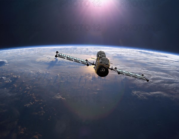 Geostationary orbit military satellite above the Earth pointed toward the rising sun