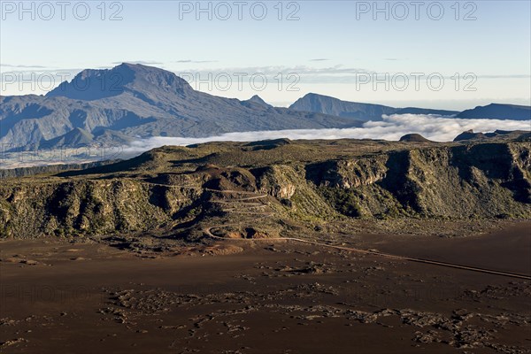 The Piton des Neiges volcano rising behind a road to the Piton de la Fournaise volcano