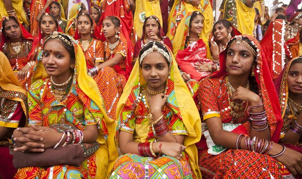 Young women in typical colourful traditional Rajasthani costume at the camel market and livestock market