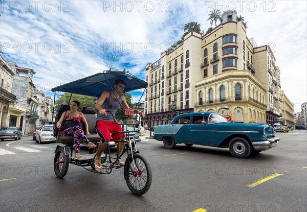 Classic car and bike rickshaw on the road junction at the Hotel Telegrafo