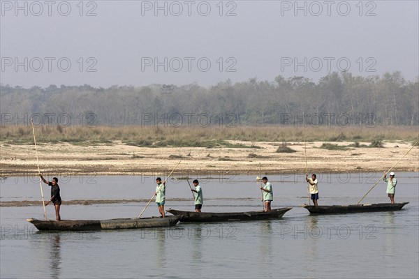 Nepalese men in dugouts on the East Rapti River at Sauraha