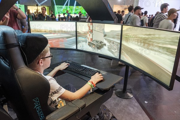 Junge plays simulation of a car race at Gamescom