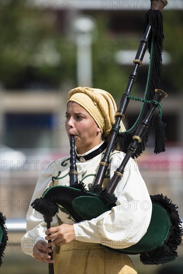 Musician in traditional costume playing the bagpipes