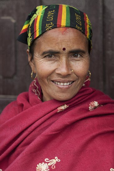 Nepalese woman with colourful headscarf and red cape