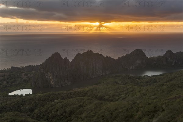 Sun breaking through the clouds over the South Pacific behind the Linderalique Rocks