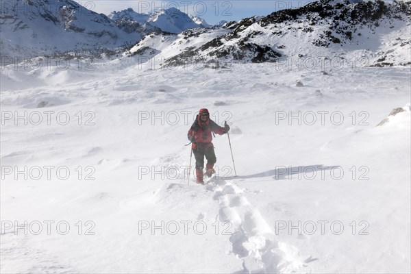 Woman with snowshoes walking to the Great Fosses Lake