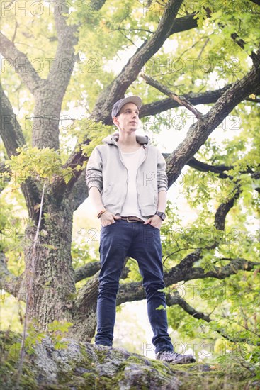 Young man standing by himself in a forest