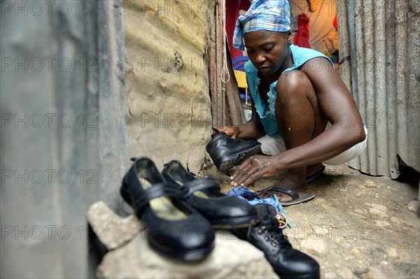 Woman shining the shoes of her children for their first day of school