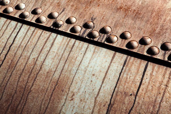 Rusted metal construction with rivets