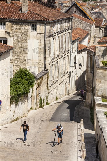 Two boys walking up the steep hill of Rue des Jacobins