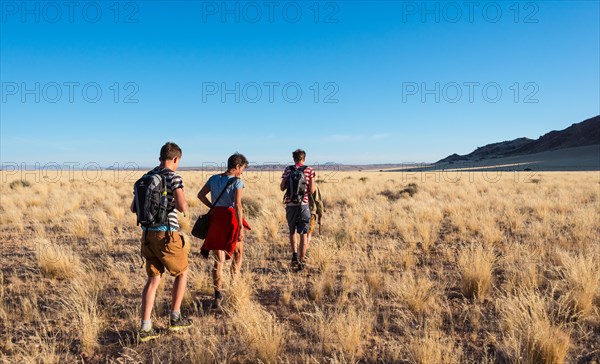 Three hikers in the savannah near the Naukluft Mountains