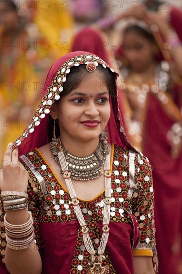 Young women in typical colourful traditional Rajasthani costume at the camel market and livestock market