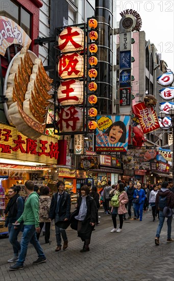 Many pedestrians crowded into pedestrian zone with lots of advertising signs for restaurants and shopping centers