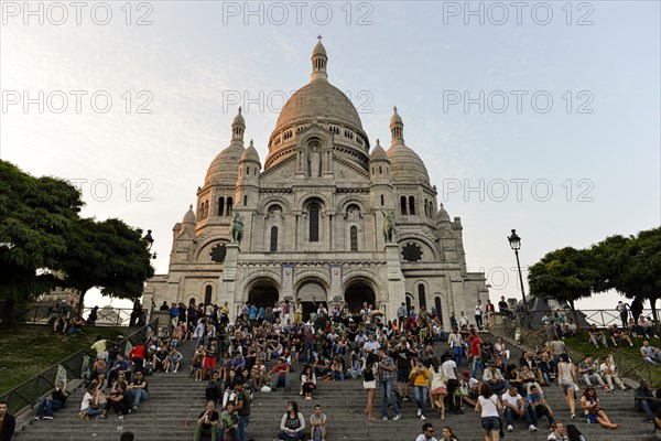 Tourists in front of the Basilica of the Sacred Heart of Paris or Sacre-Coeur de Montmartre