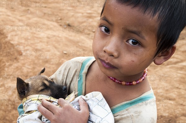 Boy from an ethnic minority holding a puppy