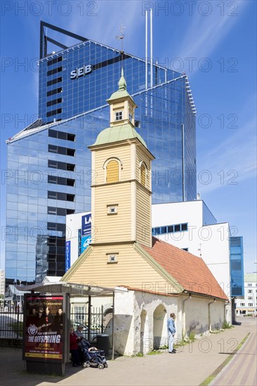 Wooden church in front of modern building of SEB bank in the financial and business district