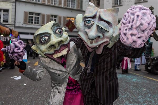 Pair wearing masks holding a brain