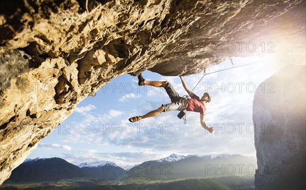 Freeclimber with helmet climbing on a rock face