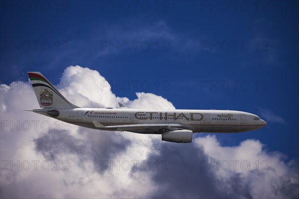 A6-EYK Etihad Airways Airbus A330-243 in flight against a cloudy sky