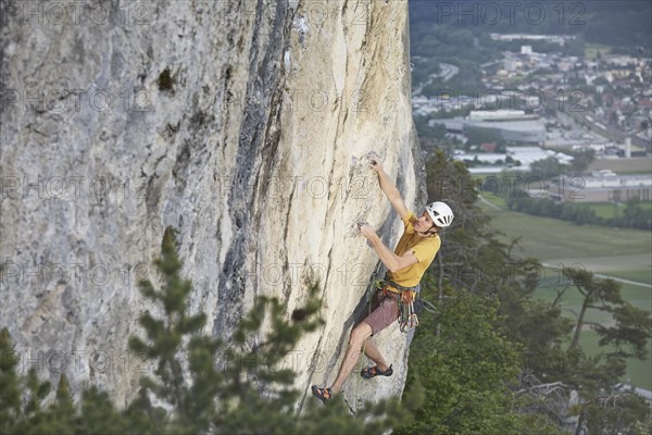 Freeclimber with helmet climbing on a rock face