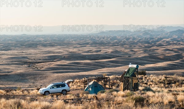 SUV next to tent and small hut