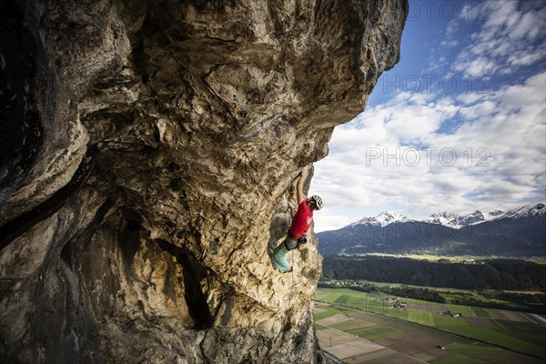 Freeclimber with helmet climbing on a rock face