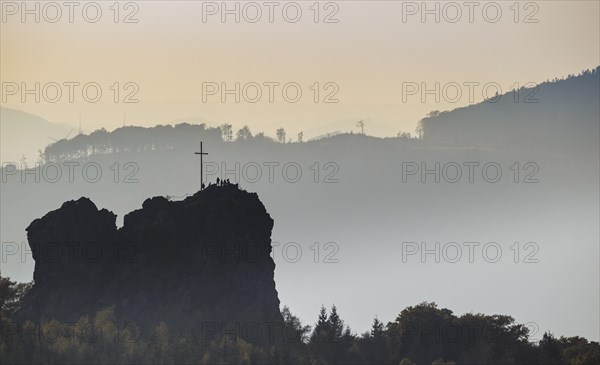 Bruchhauser Steine rocks with a group of visitors at the summit cross