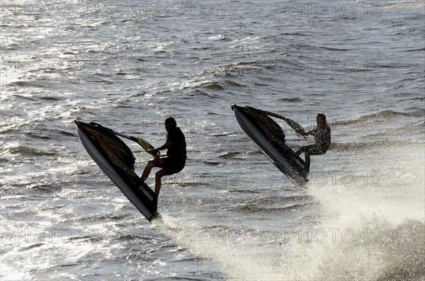 Two men riding water scooters