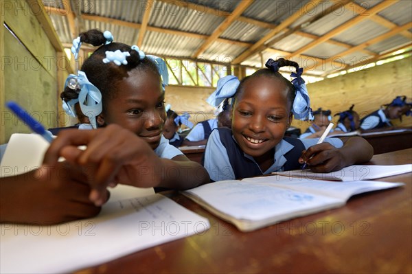 Two girls writing in a notebook