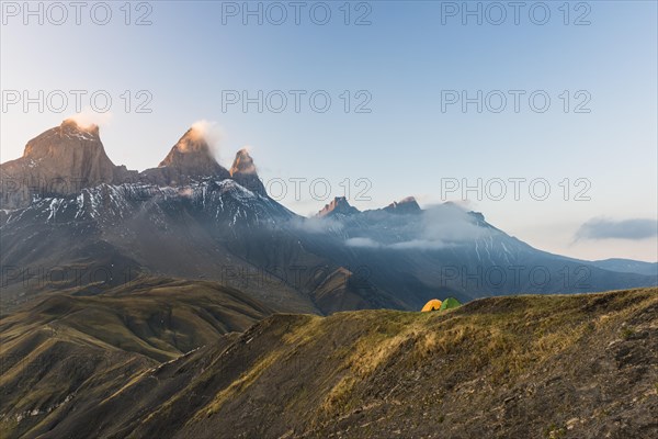 Aiguilles d'Arves mountain at dawn with two tents in front